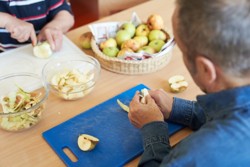 Mann zerschneidet Apfel