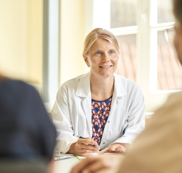 Ärztin berät Patienten am Tisch